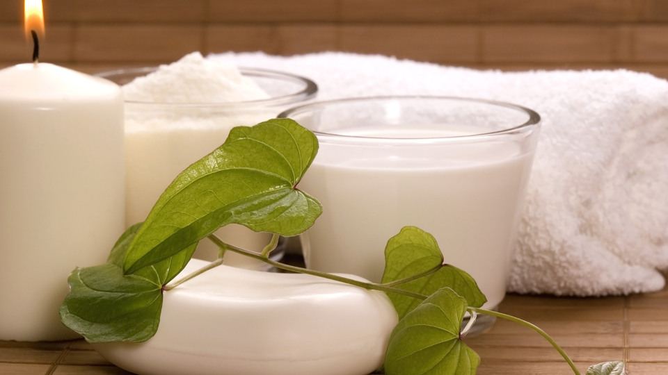 Ett tänt ljus, tvål, handduk och två glas mjölk.