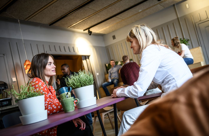 Två personer sitter och pratar vid ett bord. 