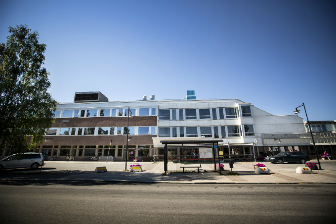 Den bruna och vita fasaden på Östersunds sjukhus betraktad från trottoaren på motsatt sida av Kyrkgatan.