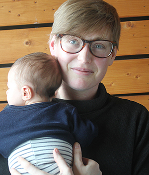 Porträttbild på en kvinna. Hon håller i en bäbis.