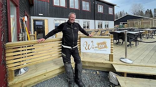 Företagaren Per-Åke Wahlund poserar framför träterassen till Åkersjöns fjällhotell.