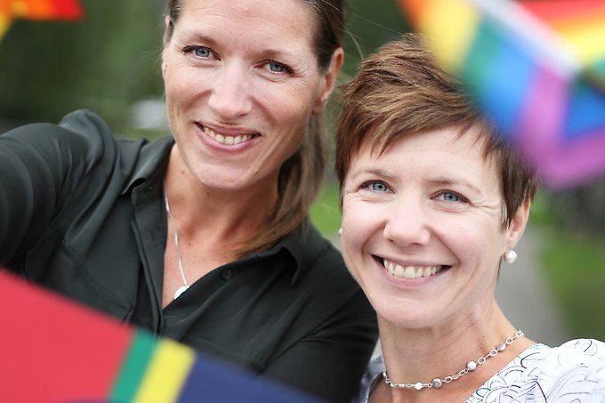porträtt på två kvinnor med prideflaggor och en samisk flagga