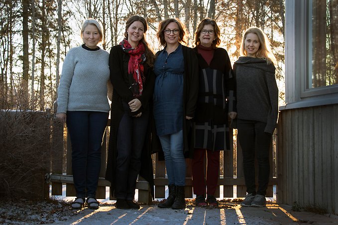 fem kvinnor står utomhus i motljus