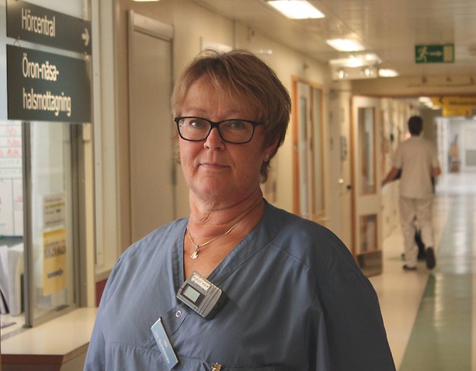 En sjuksköterska står vid sin mottagningsskylt