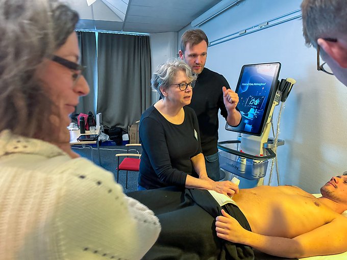 En person gör en ultraljudsundersökning av en liggande persons buk. 